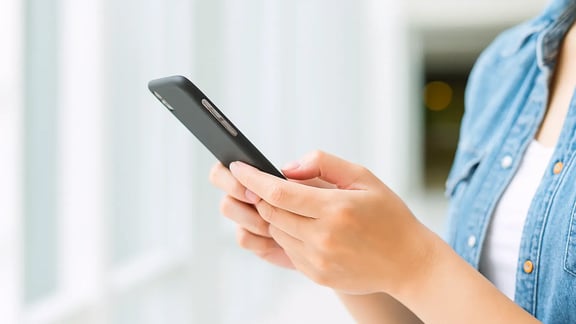 Frau schaut am Smartphone nach Informationen