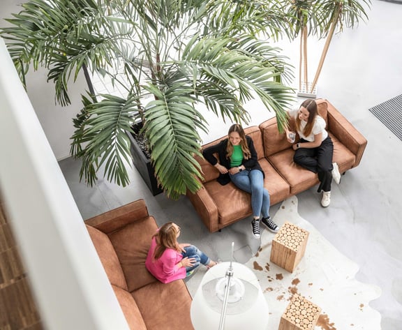 Three people sitting on couches and talking – symbolic image of sustainable relationship building in talent relationship management