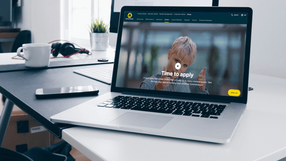 A laptop shows a Commerzbank careers page with a young woman pointing at the camera and the caption “Time to apply” - a symbolic image for a reference to the successful use of the beesite.