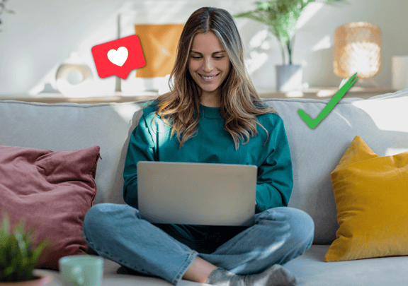Junge Frau sitzt lächelnd mit Laptop auf dem Sofa, daneben sind ein Like-Symbol und ein grüner Haken eingeblendet